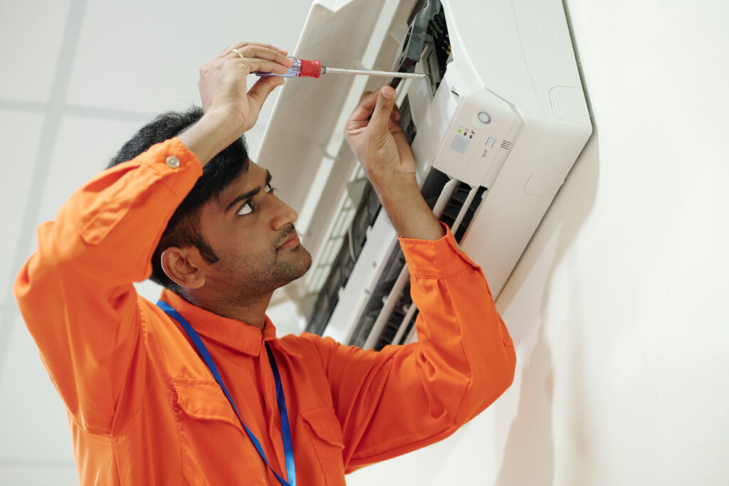 A man is engaged in repairing an air conditioning system